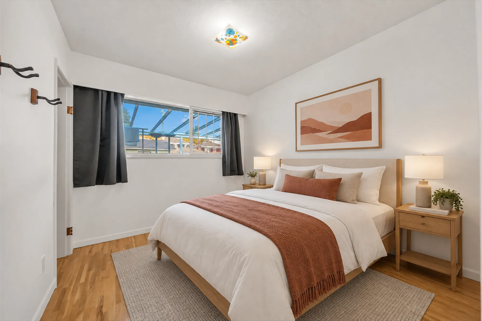 The same frame virtually staged: a bed with a rust throw, night tables and lamps, a rug, a print, plants